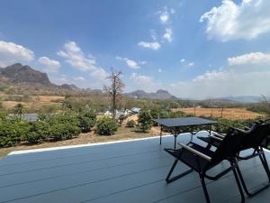 a patio with two chairs and a table on the roof at พิงภู ไทรโยค กาญจนบุรี in Sai Yok