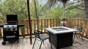 a grill and chairs on a wooden deck with a grill and a grill at Glamping MORET Tiny House M1 in Los Lirios