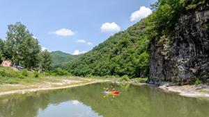 two people in a kayak on a river next to a mountain at Hongcheon Opera Bien Glamping in Hongcheon