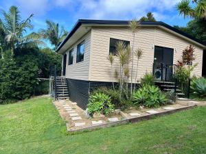 a house with palm trees in front of it at Hinterland Ocean Vista Escape in Maroochy River