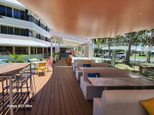 a restaurant with tables and chairs and a building at Ocean International Hotel in Mackay