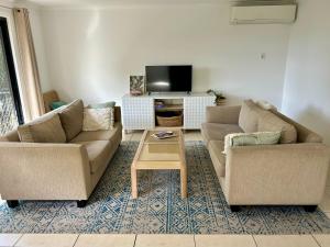 a living room with two couches and a coffee table at Hinterland Ocean Vista Escape in Maroochy River