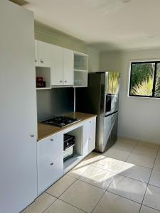 a kitchen with white cabinets and a stove at Hinterland Ocean Vista Escape in Maroochy River