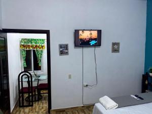 a room with a tv on a wall with a bed at Casa Miramar Tx in Trujillo