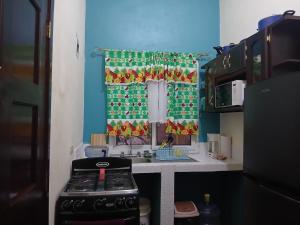 a small kitchen with a stove and a window at Casa Miramar Tx in Trujillo +11 photos