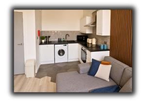a living room with a couch and a kitchen at The Vault Liverpool City Centre sleeps 4 in Liverpool