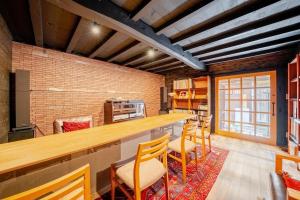 a kitchen with a long counter with chairs and a bar at cottonTSUKECHI in Nakatsugawa
