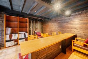 a large wooden table in a room with chairs at cottonTSUKECHI in Nakatsugawa