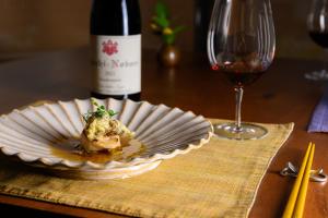 a plate of food and a glass of wine at NISEKO Inn of Youtei Raku Suisan in Kutchan