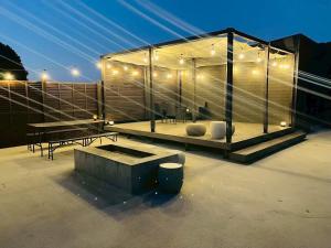 a glass house with a bench and a table at 四季の庵 糸島 1300m2 大自然のパノラマ露天風呂 駐車場5台以上 サウナ 専用BBQ施設 ペット可 in Itoshima