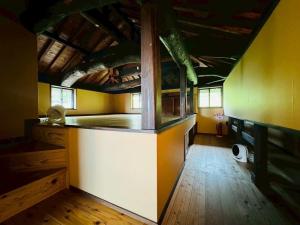a kitchen with a counter in a room with yellow walls at 四季の庵 糸島 1300m2 大自然のパノラマ露天風呂 駐車場5台以上 サウナ 専用BBQ施設 ペット可 in Itoshima