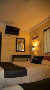 a bedroom with two beds and a mirror and a piano at Mirador wayras in Cuzco