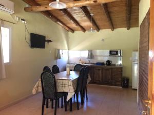 a dining room with a table and chairs and a kitchen at Ayres de Cuyo in San Rafael