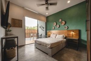 a bedroom with a bed and a green wall at Suites con piscina privada - Penca Suites Valladolid in Valladolid