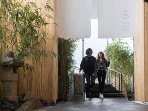 a man and a woman walking down the stairs with a suitcase at hotel kanra kyoto in Kyoto