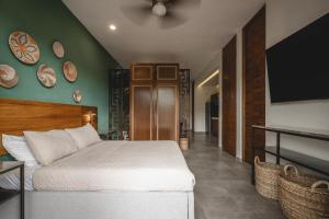 a bedroom with a bed and a flat screen tv at Suites con piscina privada - Penca Suites Valladolid in Valladolid