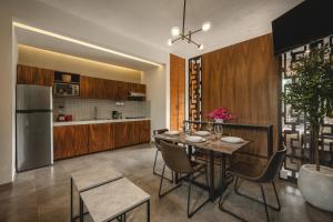 a kitchen and dining room with a table and a refrigerator at Suites con piscina privada - Penca Suites Valladolid in Valladolid
