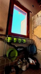 a window in a kitchen with green dishes under it at Mallma Cabañas in Tilcara +8 photos