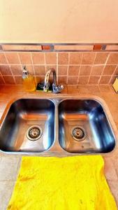 a stainless steel sink in a kitchen with a yellow towel at Mallma Cabañas in Tilcara