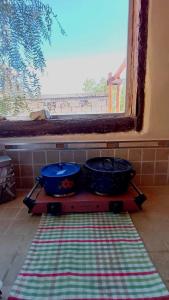 two pots sitting on a table in front of a window at Mallma Cabañas in Tilcara