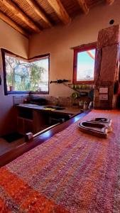 a kitchen with a rug on the floor and two windows at Mallma Cabañas in Tilcara