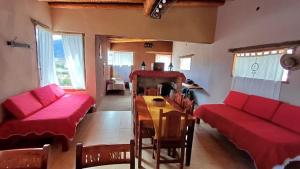 a living room with a red couch and a table at Mallma Cabañas in Tilcara