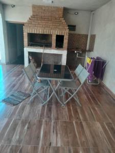 a table and chairs in a room with a fireplace at Departamento Briana in Villa Unión