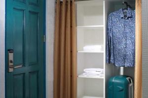 a door to a closet with a shirt and a suitcase at 1001 Nights Boutique Inn in Cagayan de Oro