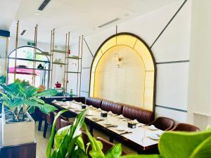 a dining room with a long table and plants at Sky House Apartment in Tam Kỳ