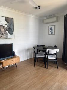 a dining room with a table and chairs and a television at Apartment on Henry in North Ward +5 photos