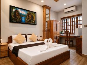 a bedroom with two beds with a desk and a desk at Dynasty Boutique Hotel in Phnom Penh