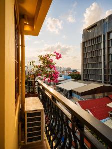 a balcony with a plant with pink flowers on it at Dynasty Boutique Hotel in Phnom Penh