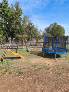 two swings in a park with a playground at Cabaña Rincón de Colbùn in Colbún