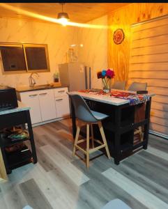 a kitchen with a desk and a counter with chairs at Cabaña Rincón de Colbùn in Colbún