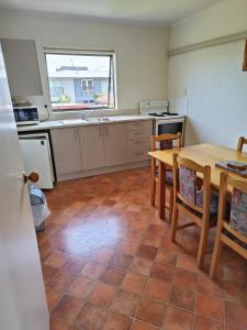 a kitchen with a table and chairs and a table and a sink at Raceway Motel in Christchurch
