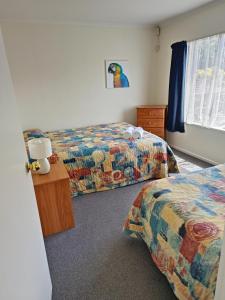 a hotel room with two beds and a window at Raceway Motel in Christchurch