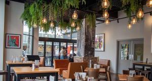 a restaurant with tables and chairs and a pillar at Mercure Wellington Abel Tasman in Wellington