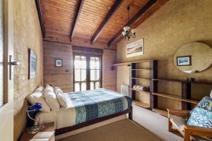 ein Schlafzimmer mit einem Bett, einem Spiegel und einem Stuhl in der Unterkunft Tea Tree - Pet Friendly - Prevelly - Margaret River in Margaret River Town