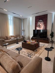 a living room with a couch and a flat screen tv at رجبانية in Jeddah