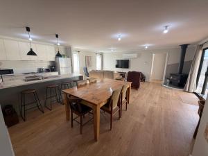 a kitchen and living room with a wooden table and chairs at Parsee Escape in Edithburgh