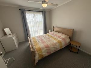 a bedroom with a bed and a window at Parsee Escape in Edithburgh