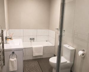 a bathroom with a toilet and a sink and a shower at Bellarine Breeze in Drysdale