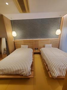 two beds sitting in a room with at tomariel in Ō-shima