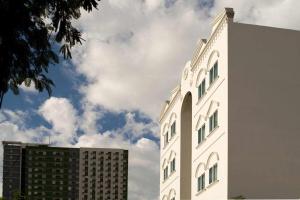 a tall white building next to two buildings at 1001 Nights Boutique Inn in Cagayan de Oro