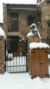a gate in front of a house with snow on it at Casas Rurales el Olmo in Riópar Viejo