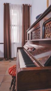 an old piano in a room with a window at Hotel Boulevard del Río in Cali +51 photos