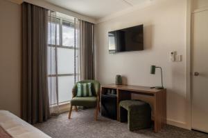 a hotel room with a desk and a window at Doonside Hotel, Blacktown in Doonside
