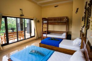 a bedroom with two bunk beds and a balcony at Summer Guesthouse Lovina in Lovina