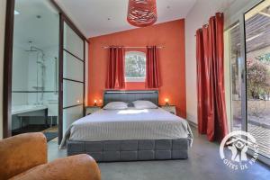 a bedroom with orange walls and a bed and a window at La grande maison in Orgères +26 photos