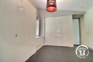 a kitchen with white cabinets and a red light at La grande maison in Orgères